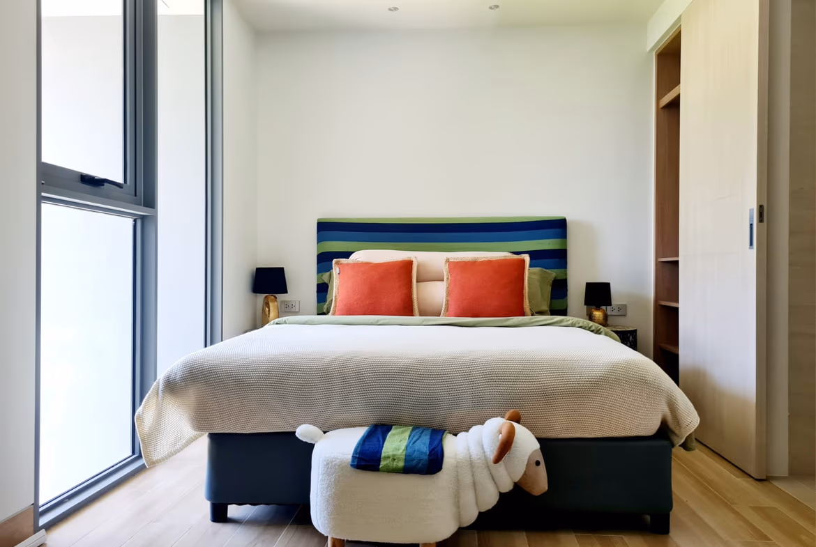 A bedroom with a view of a lush garden.